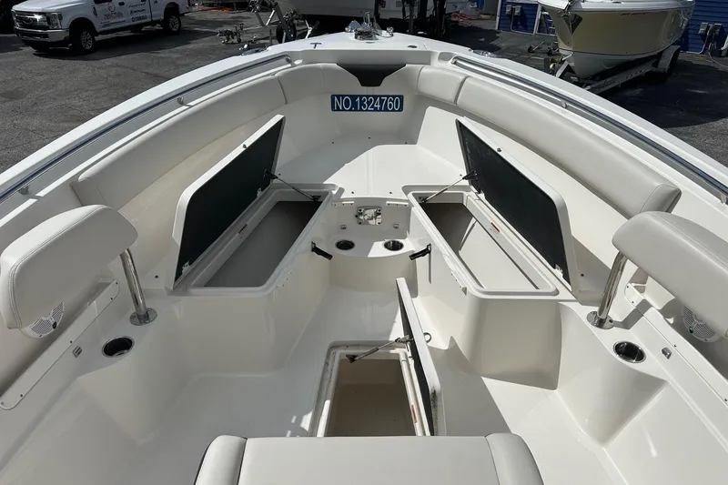 Slide: The Image of 2022 Sailfish 290 CC boat interior with open storage compartments and seating. - 13