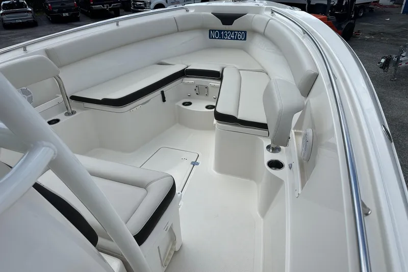 Slide: The Image of 2022 Sailfish 290 CC boat interior with white seating and cup holders. - 16