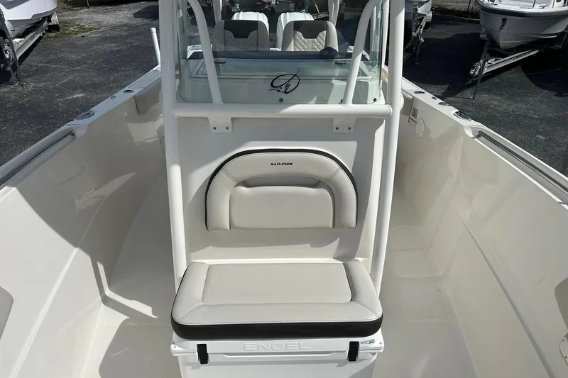 Slide: The Image of 2022 Sailfish 290 CC boat interior with cushioned seating and console. - 17