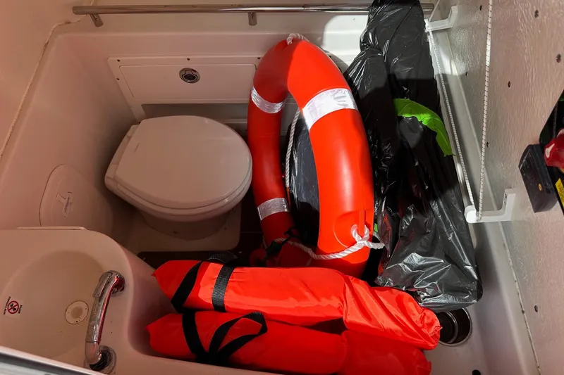 Slide: The Image of 2022 Sailfish 290 CC boat interior with life jackets and safety equipment. - 18