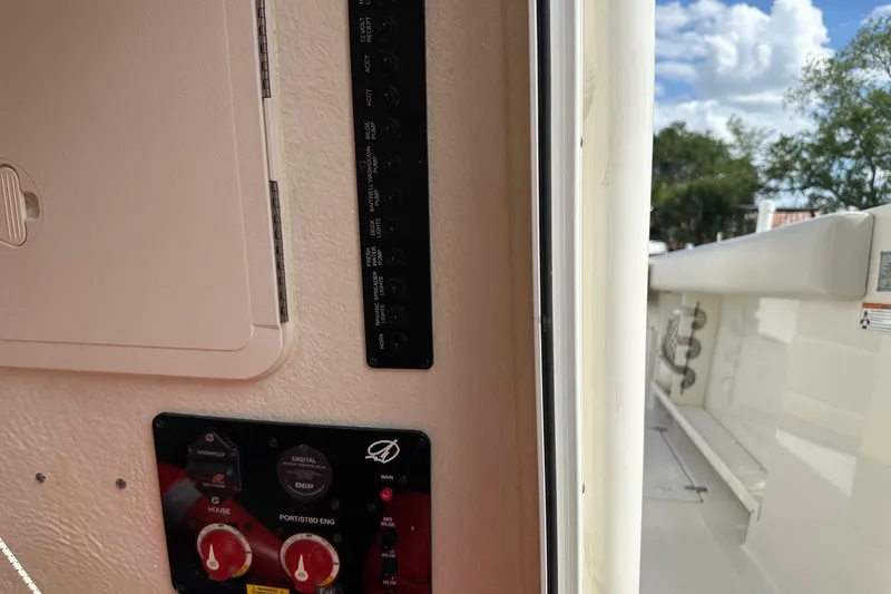 Slide: The Image of Control panel on a 2022 Sailfish 290 CC boat, featuring switches and dials. - 19