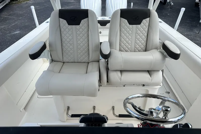 Slide: The Image of 2022 Sailfish 290 CC boat interior with dual captain's chairs and steering wheel. - 20