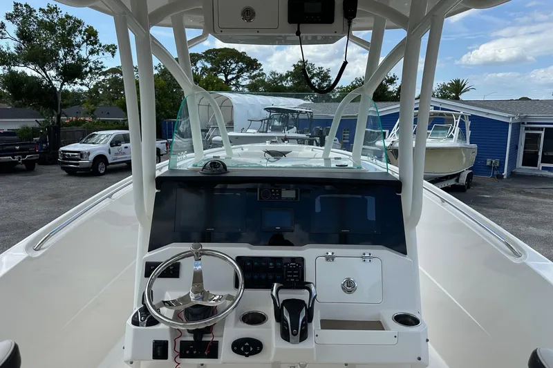 Slide: The Image of 2022 Sailfish 290 CC boat dashboard with steering wheel and navigation controls. - 21