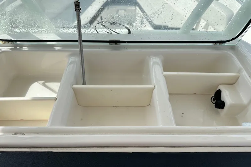 Slide: The Image of Open storage compartments on a 2022 Sailfish 290 CC boat, featuring multiple sections. - 22