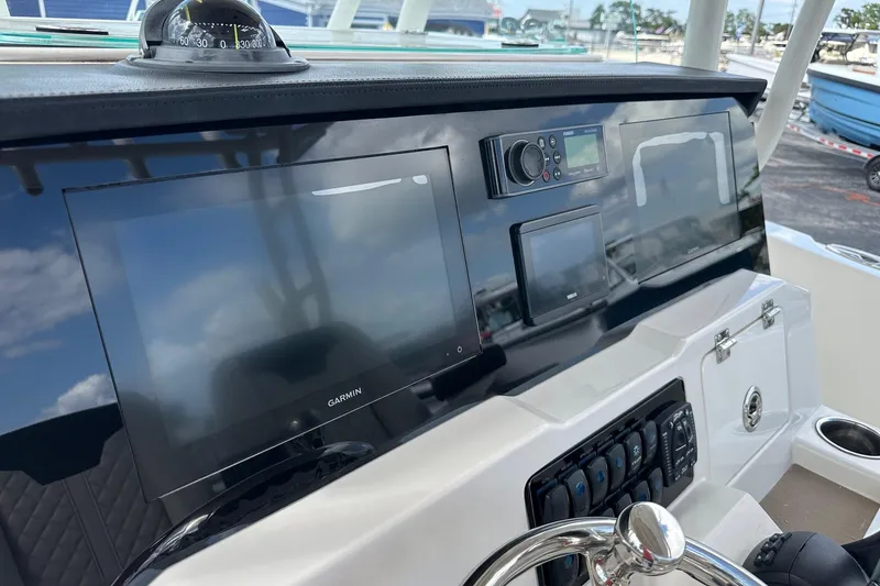 Slide: The Image of 2022 Sailfish 290 CC boat dashboard with Garmin navigation system and controls. - 24