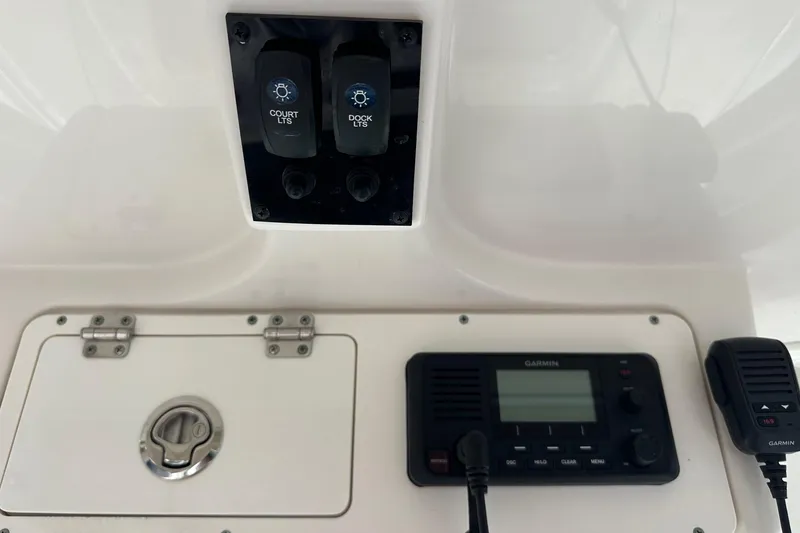 Slide: The Image of Control panel of a 2022 Sailfish 290 CC boat with Garmin device and light switches. - 26