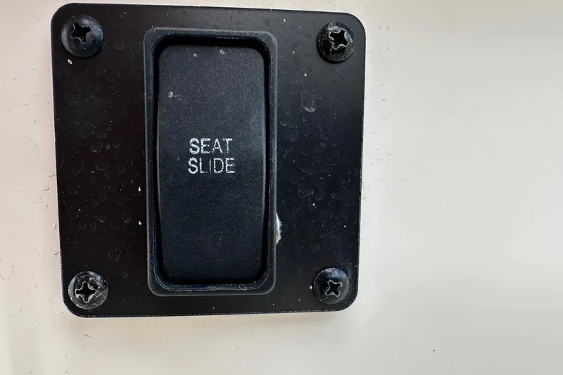 Slide: The Image of Seat slide control on 2022 Sailfish 290 CC boat, black panel with screws. - 27