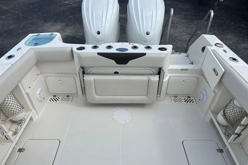 Slide: The Image of 2022 Sailfish 290 CC boat deck with seating, storage, and dual outboard motors. - 33