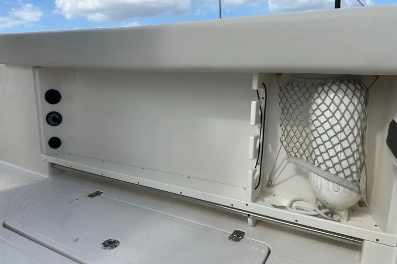 Slide: The Image of 2022 Sailfish 290 CC boat storage compartment with netting and utility features. - 37