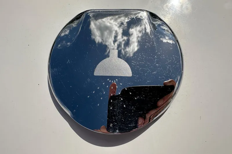 Slide: The Image of Reflective surface on 2022 Sailfish 290 CC boat, showing sky and cloud reflection. - 38