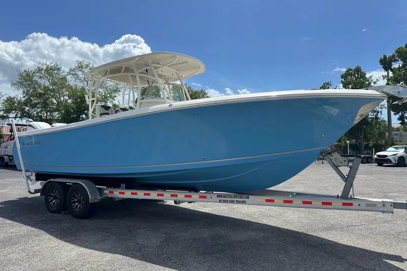 Slide: The Image of 2022 Sailfish 290 CC boat on trailer under clear blue sky. - 7