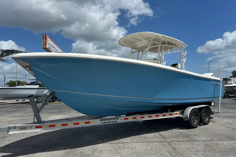 Slide: The Image of 2022 Sailfish 290 CC boat on trailer under a cloudy sky. - 9