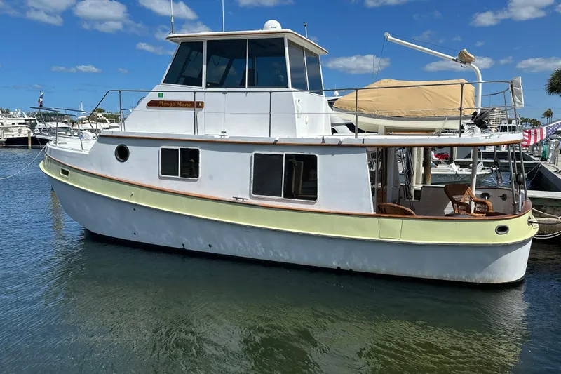 The Image of 1987 Kadey-Krogen Manatee 36 boat docked in a marina under a clear blue sky. - 1