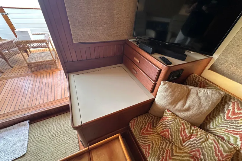 Slide: The Image of Cozy interior of 1987 Kadey-Krogen Manatee 36 with TV, cushions, and wooden furniture. - 13