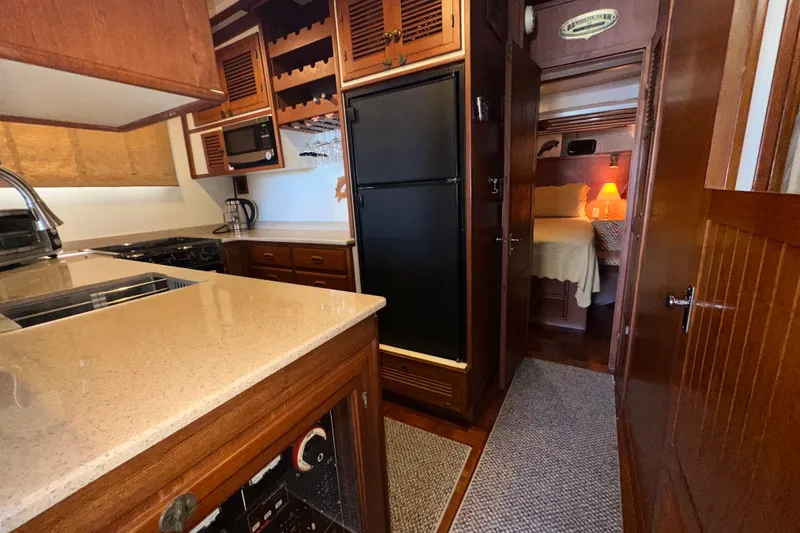 Slide: The Image of 1987 Kadey-Krogen Manatee 36 yacht interior with kitchen and cozy bedroom. - 24