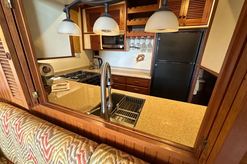 Slide: The Image of 1987 Kadey-Krogen Manatee 36 yacht kitchen with modern appliances and wooden cabinetry. - 28