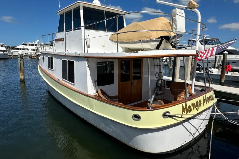 Slide: The Image of 1987 Kadey-Krogen Manatee 36 yacht docked at marina, featuring classic design and American flag. - 3