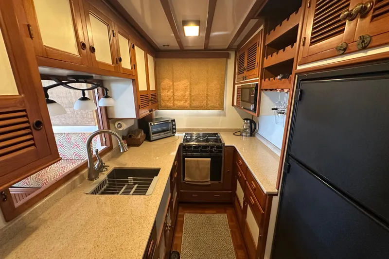 Slide: The Image of 1987 Kadey-Krogen Manatee 36 yacht kitchen with wooden cabinets and modern appliances. - 30