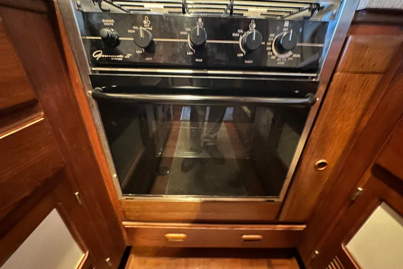 Slide: The Image of Oven in 1987 Kadey-Krogen Manatee 36 yacht galley, featuring wooden cabinetry. - 35