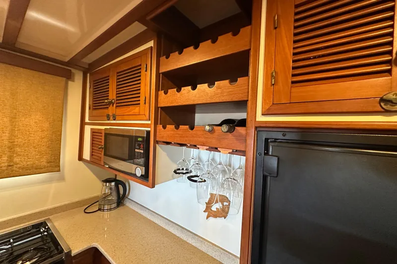 Slide: The Image of 1987 Kadey-Krogen Manatee 36 galley with wooden cabinets, wine rack, and microwave. - 38