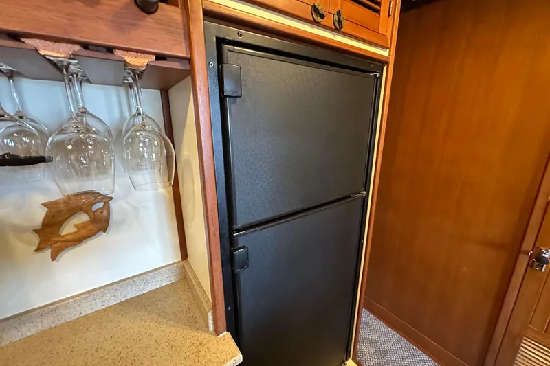 Slide: The Image of 1987 Kadey-Krogen Manatee 36 interior with fridge and wine glass rack. - 41