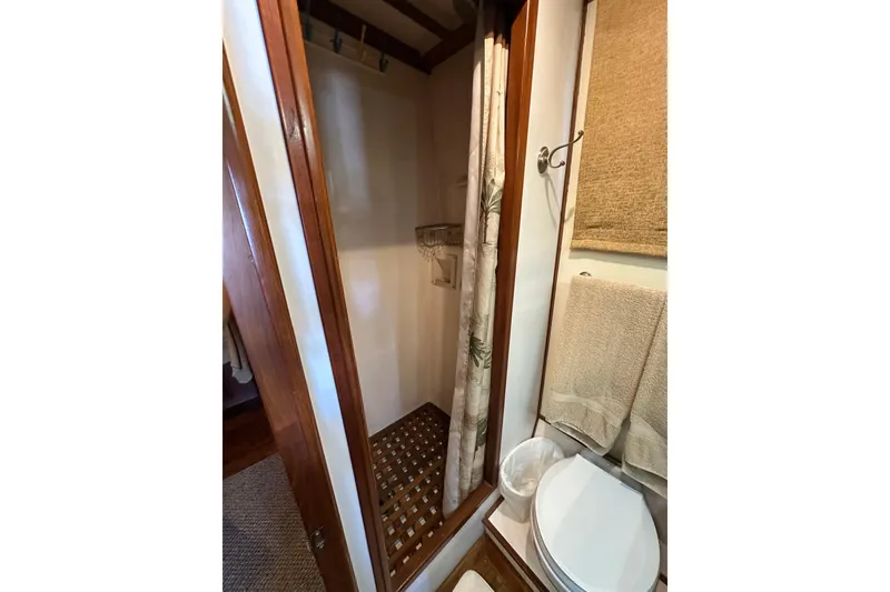 Slide: The Image of 1987 Kadey-Krogen Manatee 36 bathroom with shower, wooden accents, and towel rack. - 46