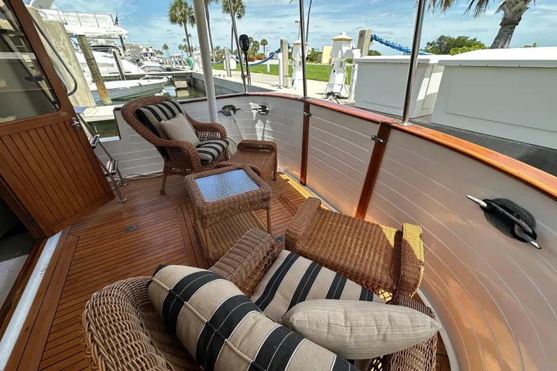 Slide: The Image of Cozy deck of 1987 Kadey-Krogen Manatee 36 with wicker chairs and striped cushions. - 6