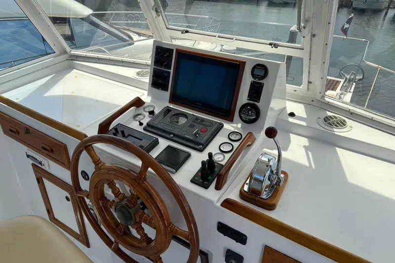 Slide: The Image of Helm of 1987 Kadey-Krogen Manatee 36 with wooden wheel and navigation controls. - 65