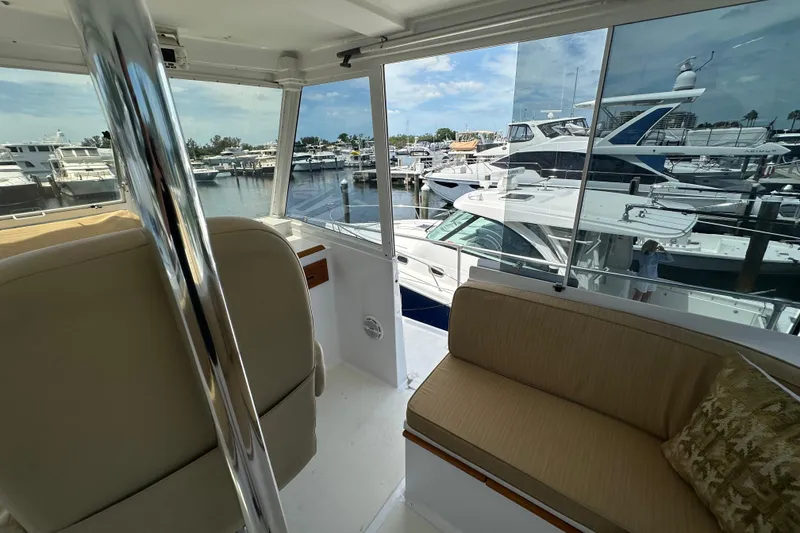 Slide: The Image of Interior view of 1987 Kadey-Krogen Manatee 36 yacht at marina, showcasing seating and windows. - 76