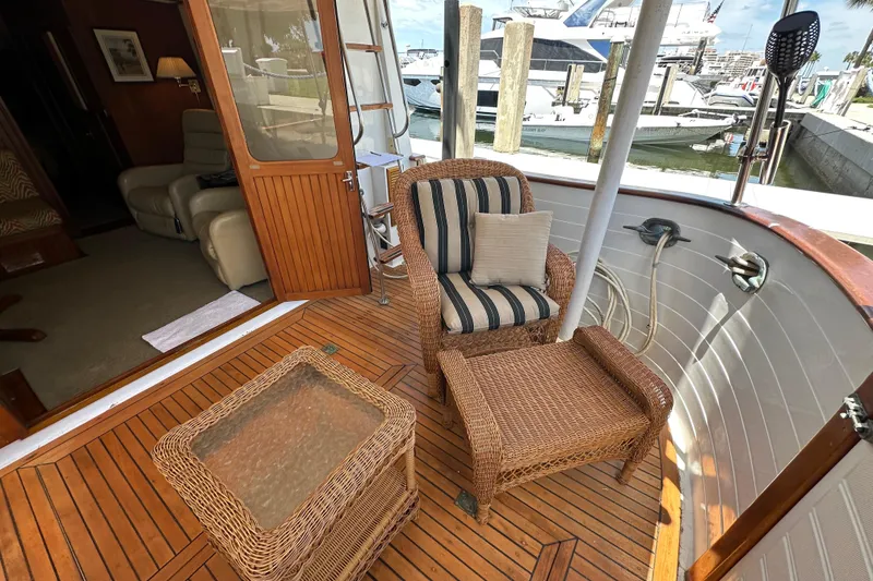 Slide: The Image of 1987 Kadey-Krogen Manatee 36 yacht deck with wicker furniture and marina view. - 8