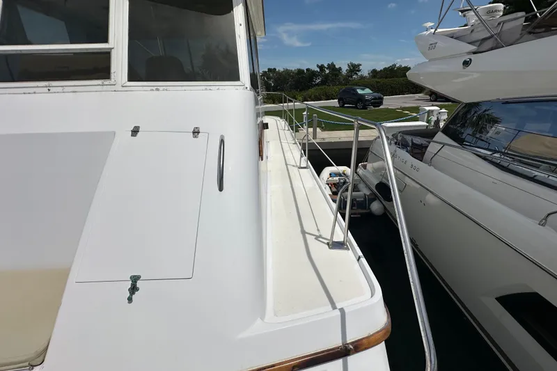 Slide: The Image of 1987 Kadey-Krogen Manatee 36 yacht docked beside another boat, showcasing deck and railing. - 82