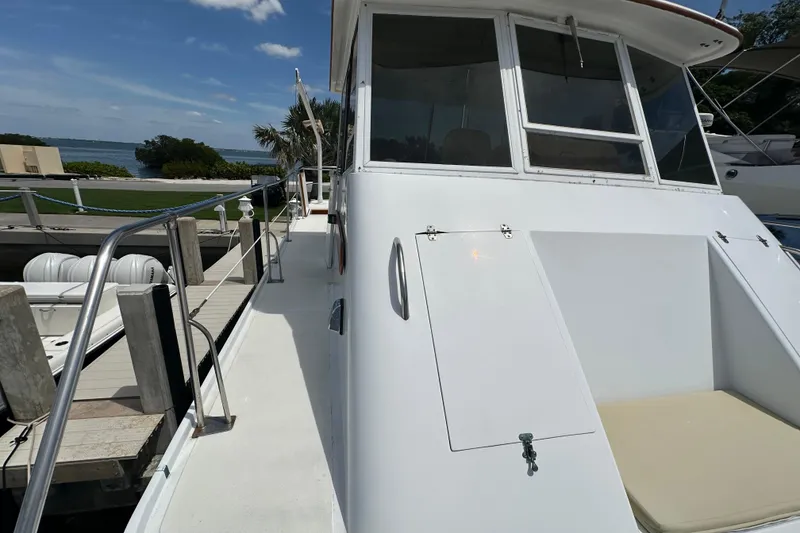 Slide: The Image of 1987 Kadey-Krogen Manatee 36 yacht docked, showcasing sleek white exterior and spacious deck. - 84