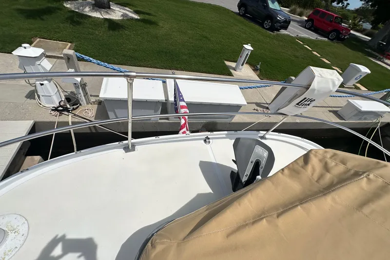 Slide: The Image of 1987 Kadey-Krogen Manatee 36 docked, featuring deck view with railing and American flag. - 87