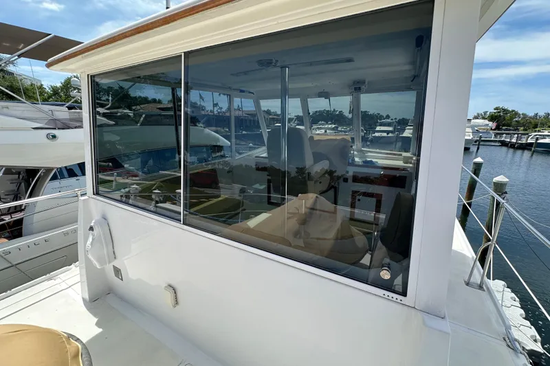 Slide: The Image of 1987 Kadey-Krogen Manatee 36 yacht with enclosed cockpit, docked at marina. - 88