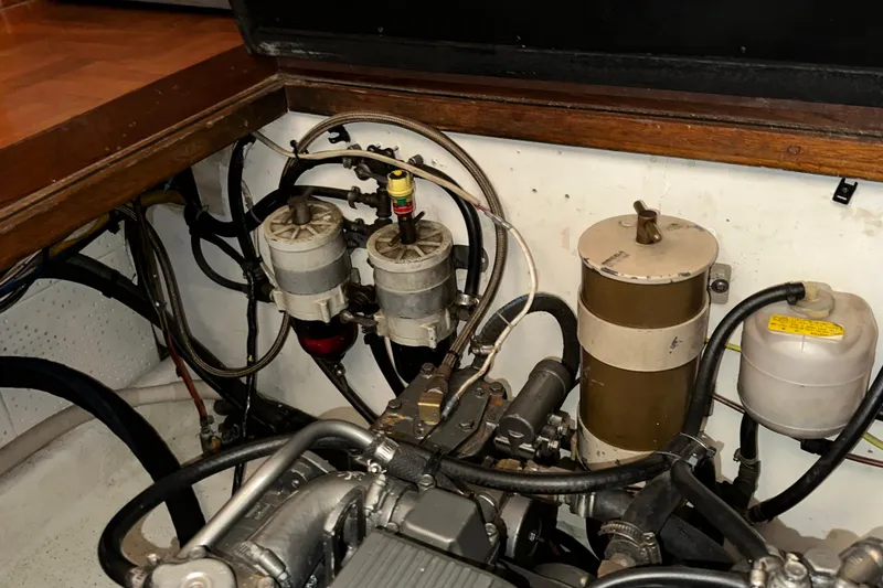Slide: The Image of Engine room of a 1987 Kadey-Krogen Manatee 36 with visible fuel filters and hoses. - 90