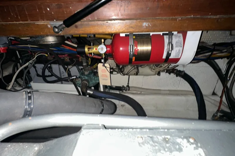 Slide: The Image of Engine room of 1987 Kadey-Krogen Manatee 36 with fire extinguisher and wiring. - 92