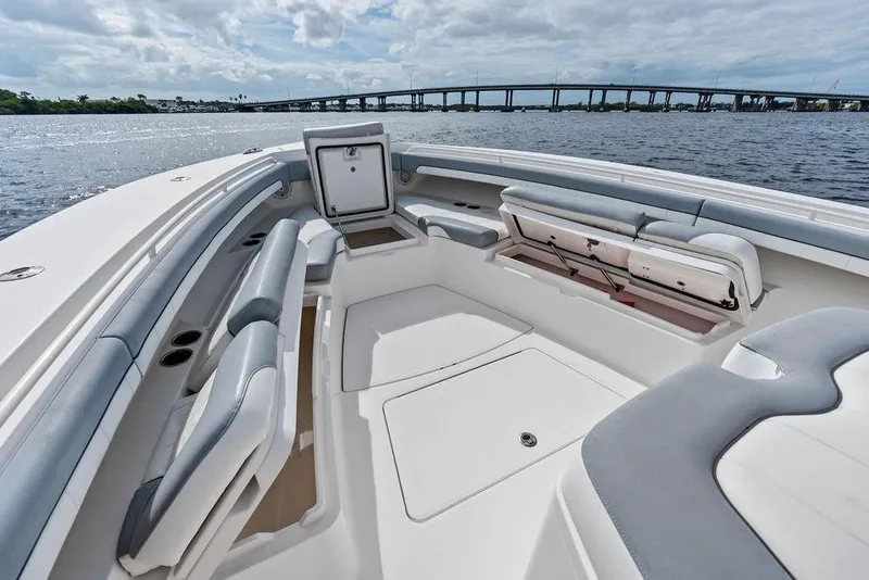 Slide: The Image of 2018 Regulator 41 boat interior with seating and storage, near a bridge over water. - 17