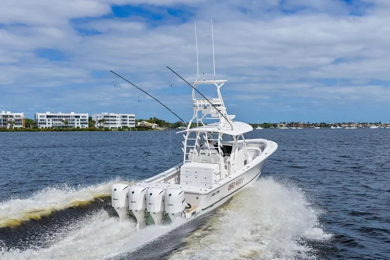Slide: The Image of 2018 Regulator 41 boat cruising on water with four engines, coastal buildings in background. - 2