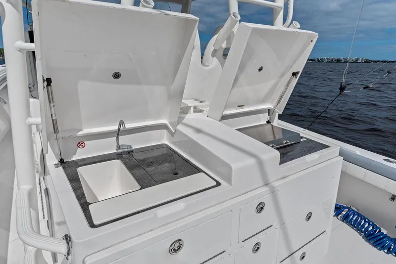 Slide: The Image of 2018 Regulator 41 boat with dual sinks and storage, docked by the water. - 32
