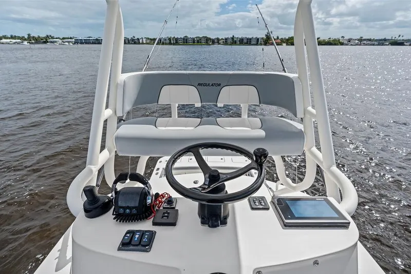 Slide: The Image of 2018 Regulator 41 boat helm with steering wheel and controls on open water. - 36