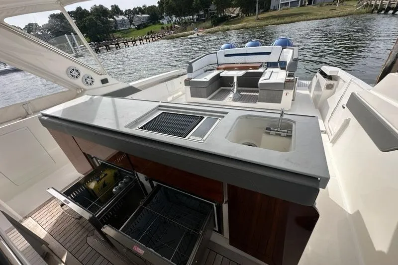 Slide: The Image of 2021 Tiara Sport 43 LS yacht with outdoor kitchen and seating area by the water. - 14