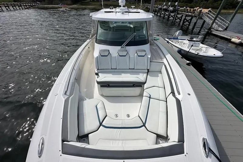 Slide: The Image of 2021 Tiara Sport 43 LS luxury boat docked, featuring spacious seating and sleek design. - 25