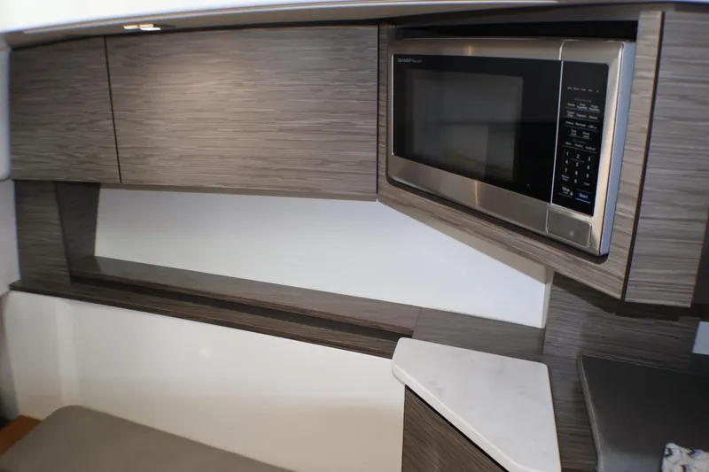 Slide: The Image of Modern kitchen interior of 2021 Tiara Sport 43 LS yacht with microwave and sleek cabinetry. - 28