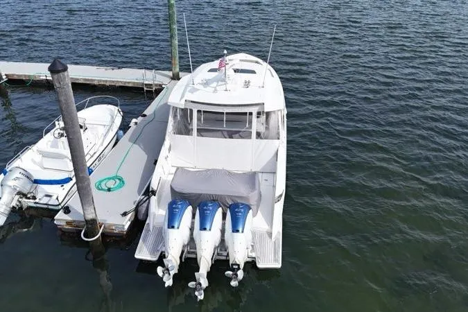 Slide: The Image of 2021 Tiara Sport 43 LS yacht docked with triple outboard engines. - 6