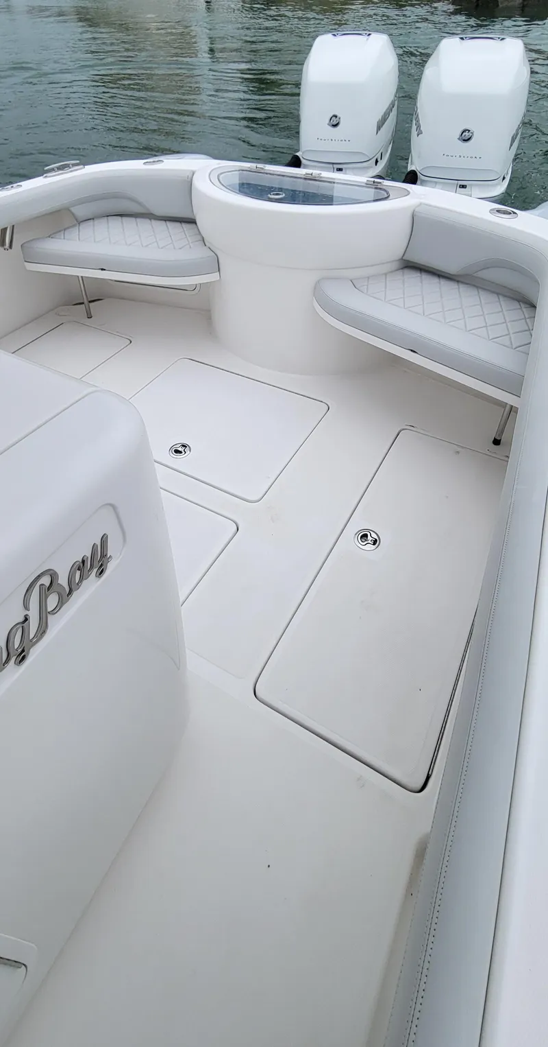 Slide: The Image of 2023 Mag Bay 33 CC boat interior with twin engines and seating. - 32