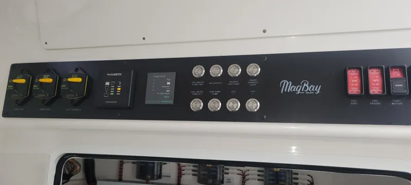 Slide: The Image of Control panel of 2023 Mag Bay 33 CC boat with switches and indicators. - 38