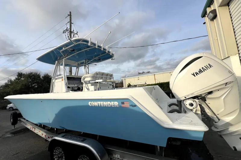 Slide: The Image of 2023 Contender 30 ST boat with Yamaha engine, parked on a trailer, under a cloudy sky. - 1