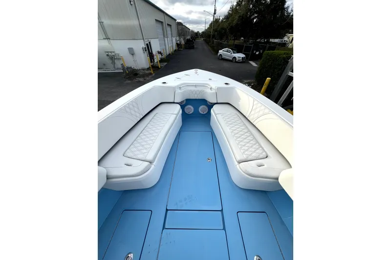 Slide: The Image of 2023 Contender 30 ST boat interior with white cushioned seating and blue deck. - 11