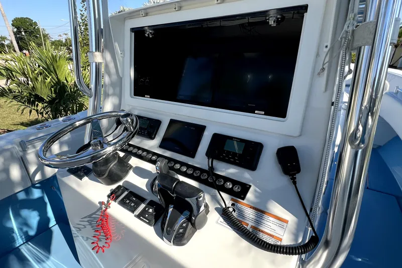 Slide: The Image of 2023 Contender 30 ST boat dashboard with steering wheel and electronic controls. - 18