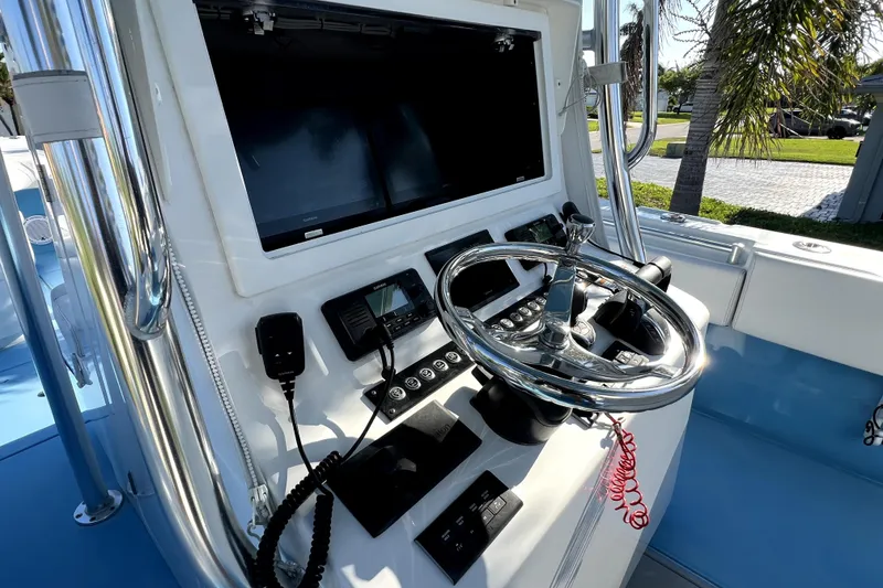 Slide: The Image of 2023 Contender 30 ST boat dashboard with steering wheel and electronic controls. - 19